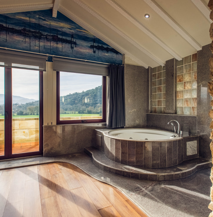Bathroom with hydro-massage bathtub and panoramic view of the outdoors