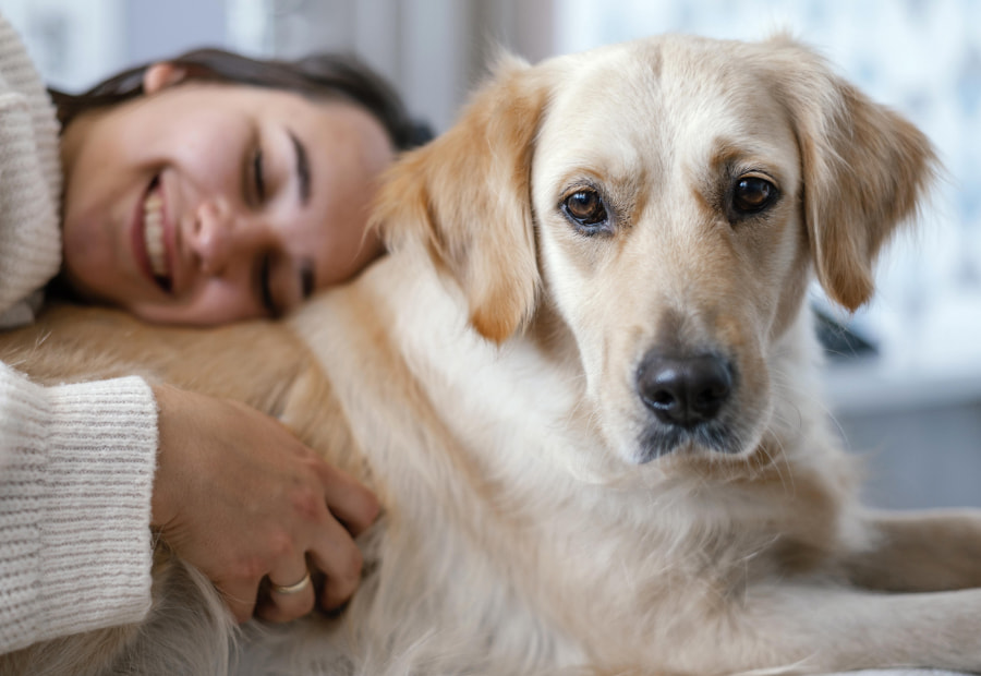 Smiling woman lying down hugging her dog