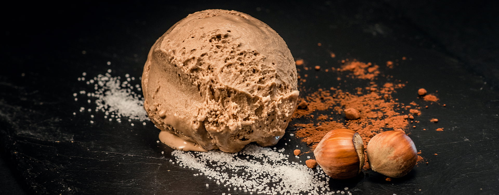 Dessert plate with a scoop of ice cream accompanied by hazelnuts