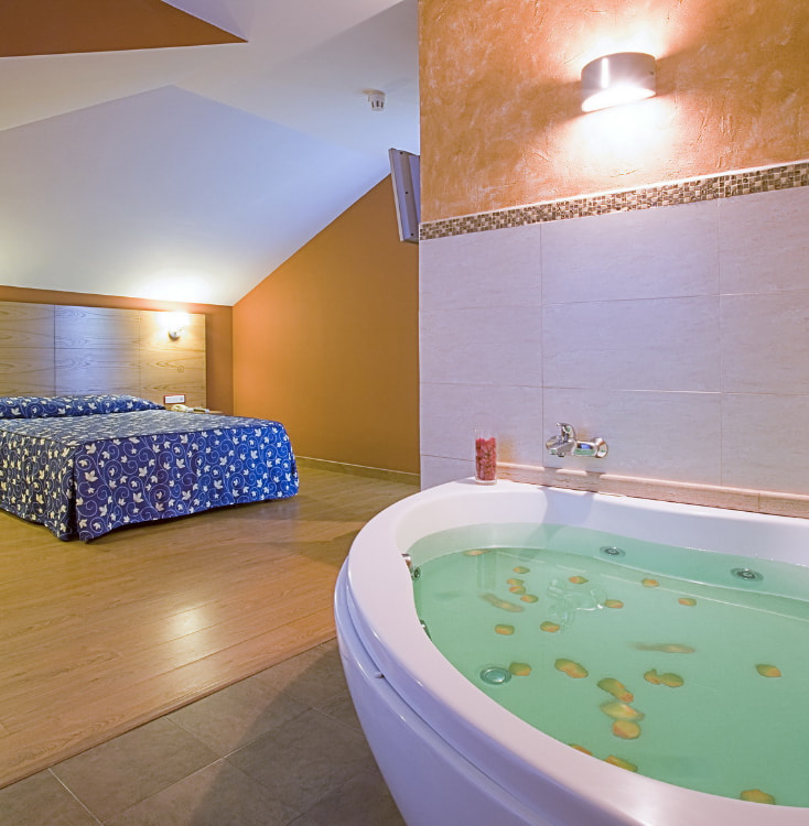 Picture of the hotel suite with double bed and whirlpool bathtub