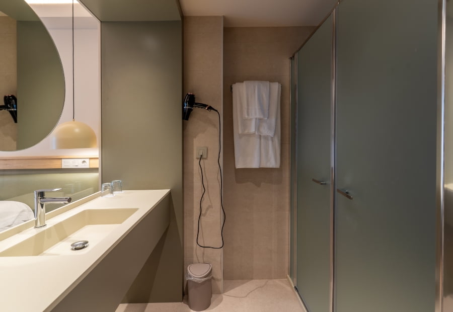 Baño de la habitación triple con ducha, lavabo y amenities
