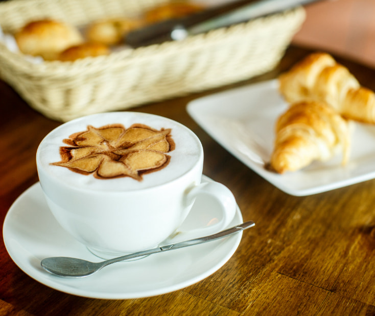 Breakfast of croissant and cup of coffee and milk