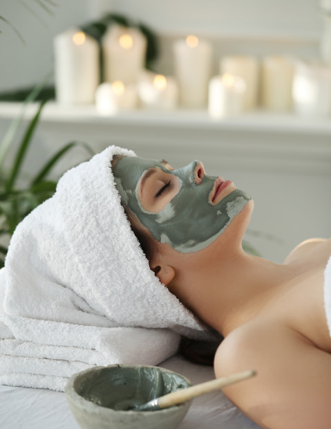 Mujer recibiendo un tratamiento facial con mascarilla