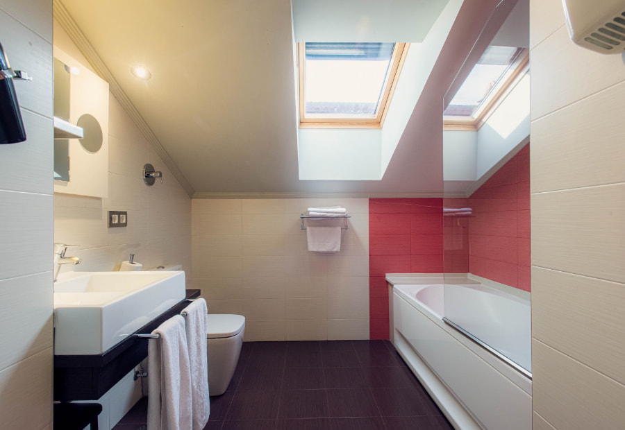 Fully equipped bathroom with bathtub and towel rail