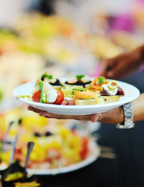 Waiter serving a plate of food in the accommodation