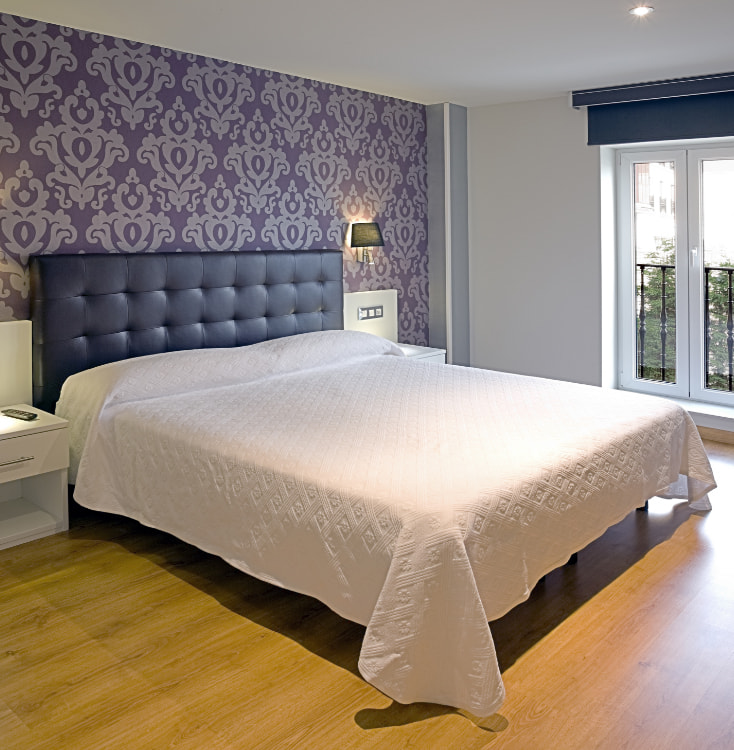 Fotografía de habitación con cama doble y ventana con vistas exteriores