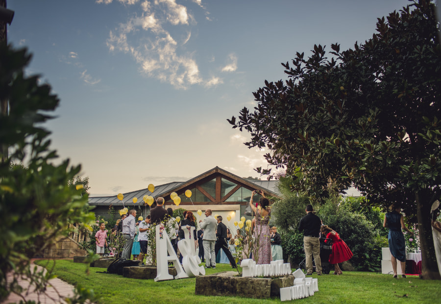 People gathered in a garden decorated with balloons