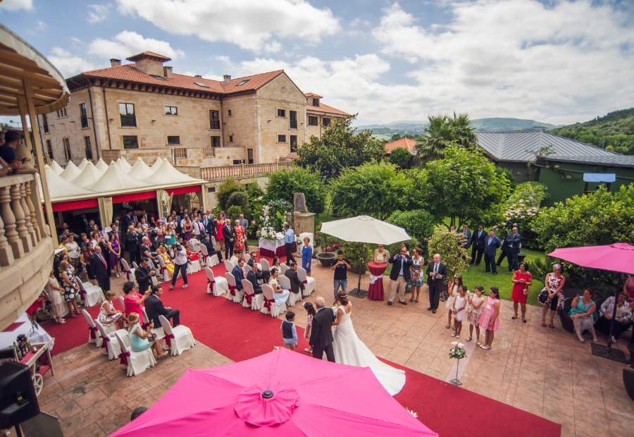 People gathered together talking and taking pictures in a decorated garden.