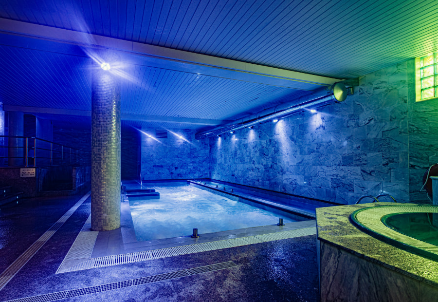 Couple lying on the submerged sun loungers in the spa pool