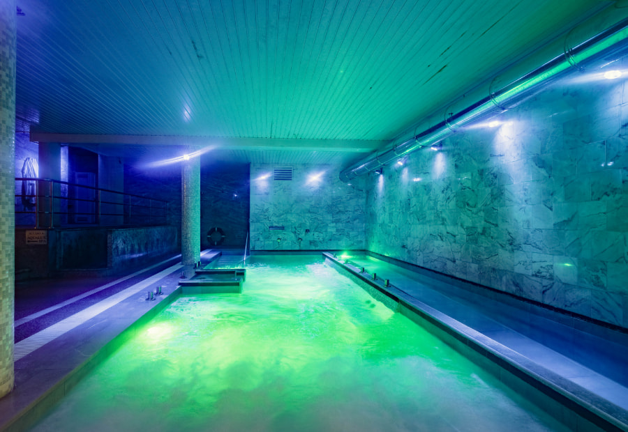 Couple lying on the submerged sun loungers in the spa pool